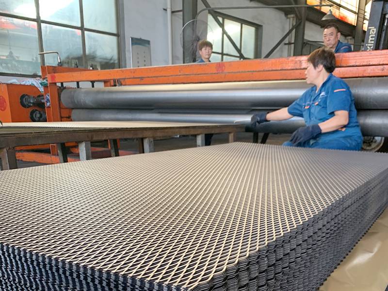 工人将整平后的批量钢板网放在防潮纸上。