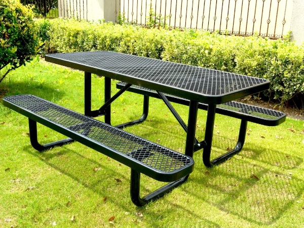 户外绿色的草坪上有一套黑色钢板网材料的桌椅。