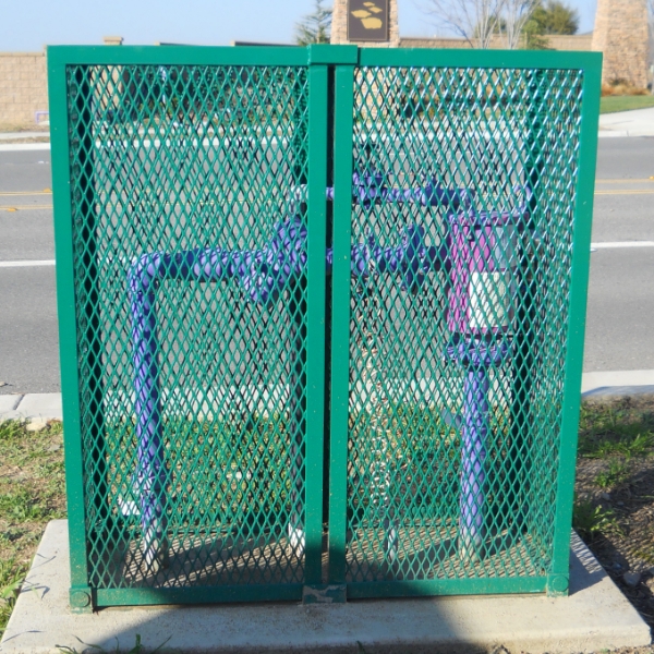 绿色的钢板网防护罩将户外管道保护起来。